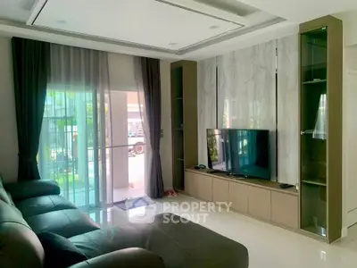 Modern living room with sleek TV unit and large windows for natural light.