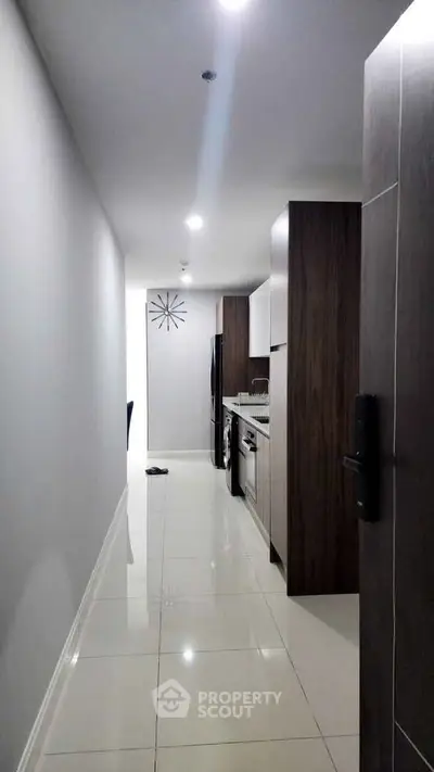 Modern narrow kitchen with sleek appliances and glossy white tiles