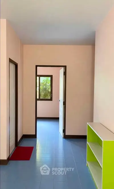 Bright interior hallway with colorful shelving and natural light from windows.