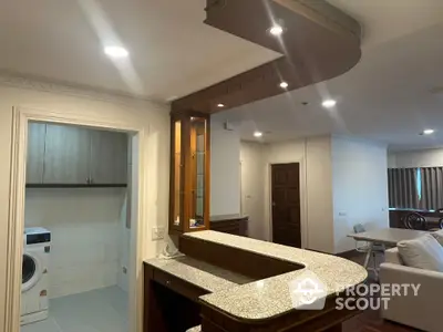 Spacious open-plan living area with modern kitchen and laundry facilities