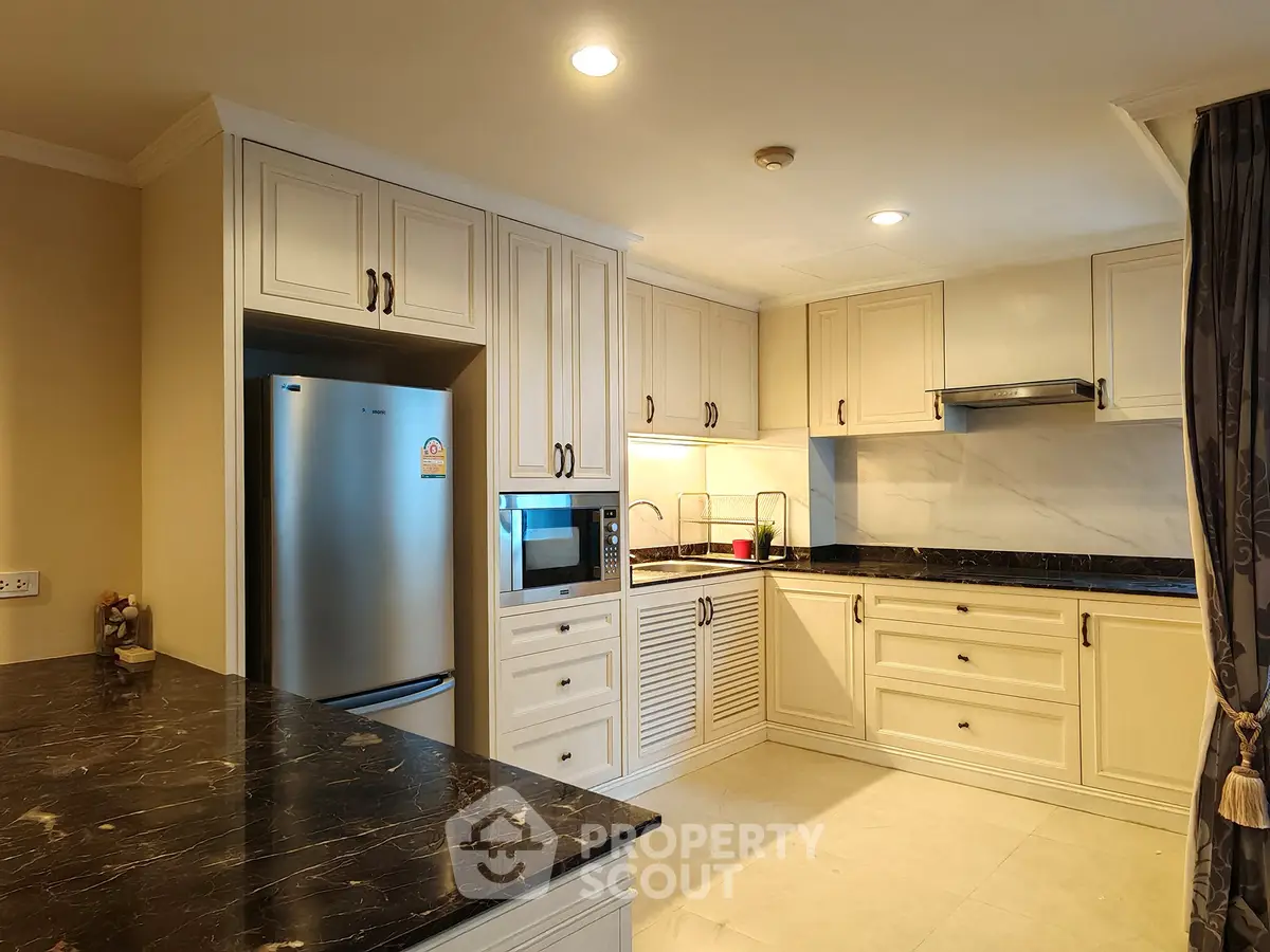 Elegant kitchen with marble countertops and modern appliances in a spacious layout.