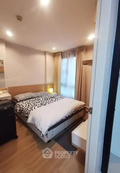 Cozy bedroom with modern decor and ample natural light in a stylish apartment.