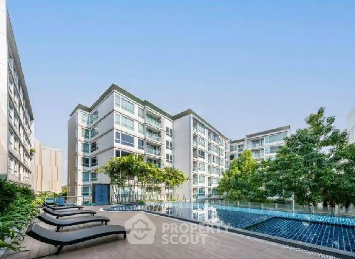Modern apartment complex with pool and lush greenery, ideal for luxury urban living.