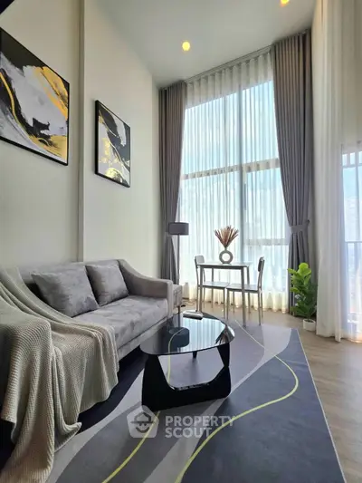 Modern living room with stylish decor and large windows offering natural light.