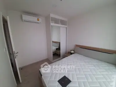 Modern bedroom with mirrored closet and air conditioning unit