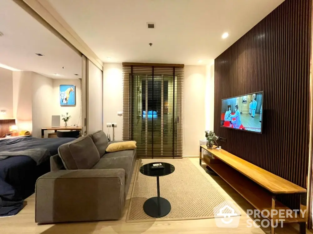 Modern living room with cozy sofa and wall-mounted TV in stylish apartment