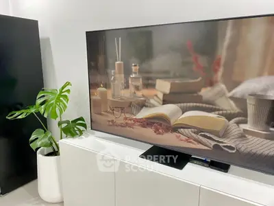 Modern living room with stylish decor and large flat-screen TV