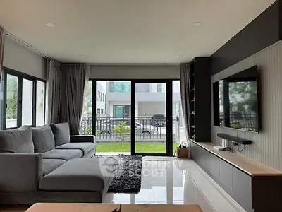 Modern living room with large windows and stylish gray sofa