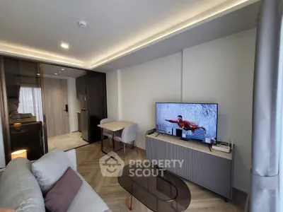 Modern living room with stylish furniture and large TV, featuring elegant lighting and sleek design.