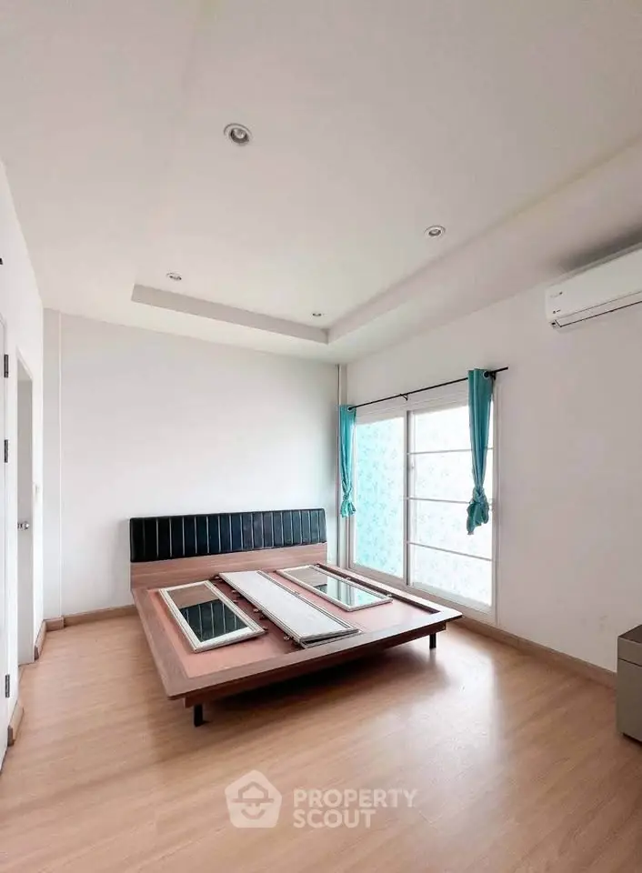 Spacious bedroom with modern design and large windows for natural light.