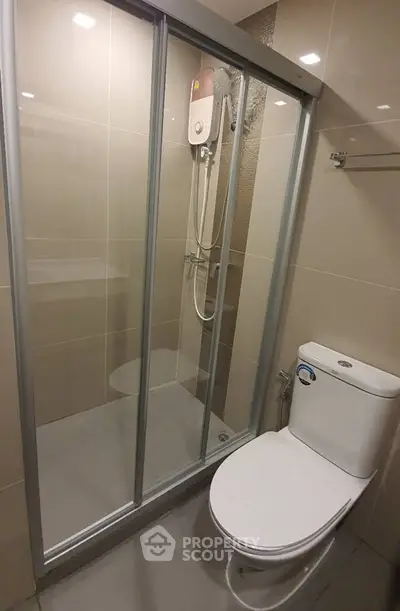 Modern bathroom with glass shower enclosure and sleek toilet design.
