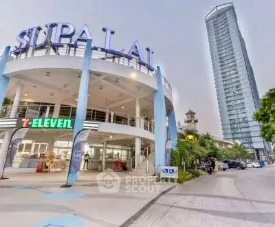 Modern high-rise building with convenient 7-Eleven store at entrance, ideal urban living.