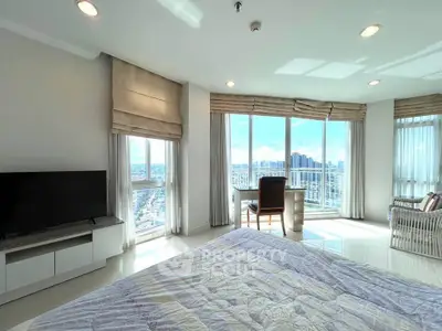 Spacious bedroom with panoramic city views and elegant furnishings