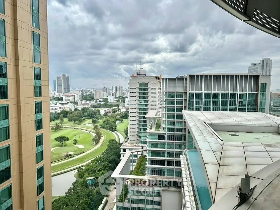Stunning cityscape view from high-rise building with lush greenery and modern architecture.