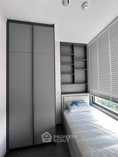 Modern bedroom with sleek wardrobe and large window for natural light