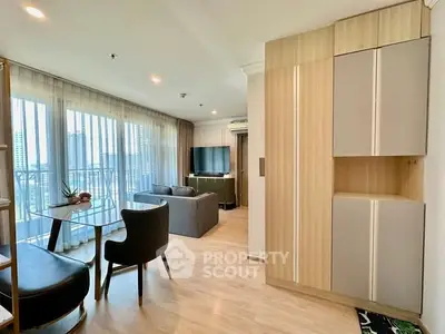 Modern living room with large windows and stylish furniture in a high-rise apartment.