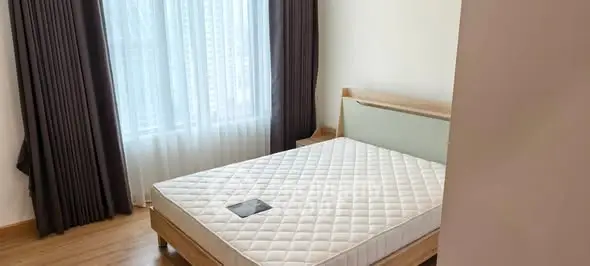 Bright and cozy bedroom with large window and modern furnishings.