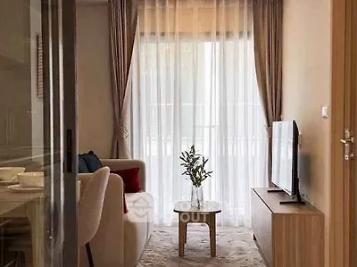 Cozy living room with elegant decor and natural light through sheer curtains.
