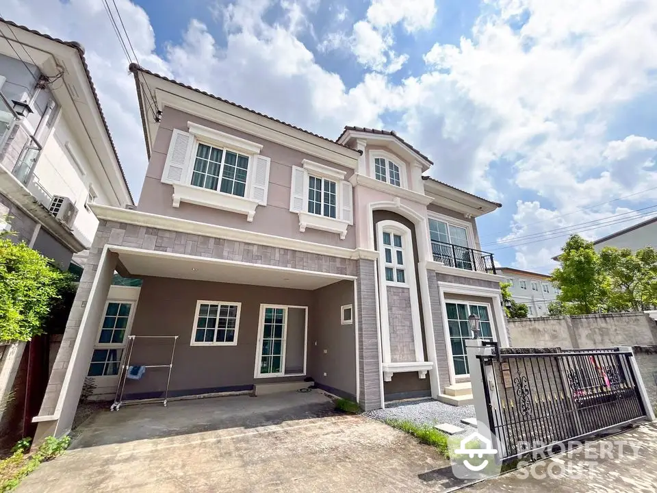 Stunning modern two-story house with spacious driveway and elegant facade under a bright blue sky.