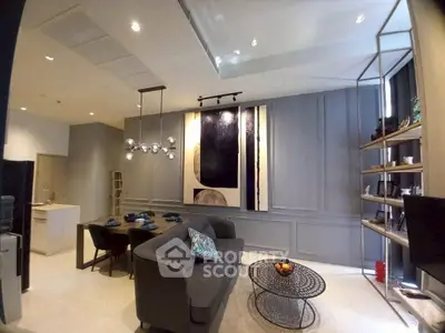 Modern living room with stylish decor and open kitchen layout, featuring contemporary furniture and elegant lighting.