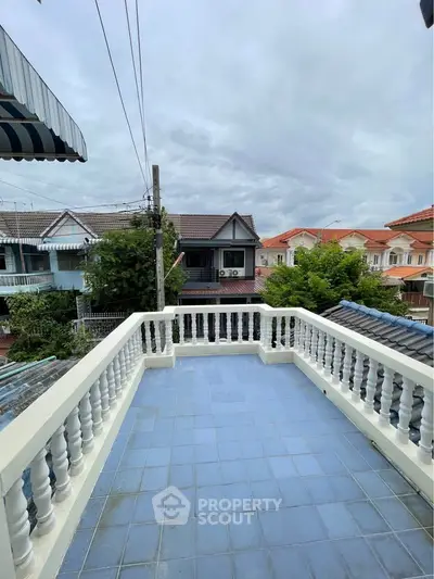 Charming balcony with blue tiles offering a scenic neighborhood view, perfect for relaxation and outdoor enjoyment.