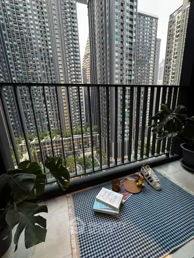 Chic urban balcony with cityscape view, perfect for relaxation and reading.