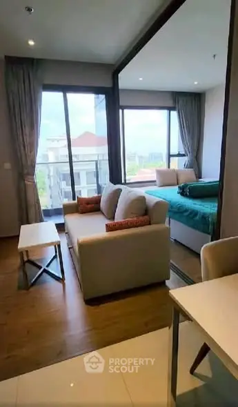 Modern studio apartment with open layout and large windows offering city views.