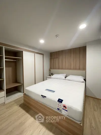 Spacious modern bedroom with built-in wardrobe and king-size bed in a stylish apartment.