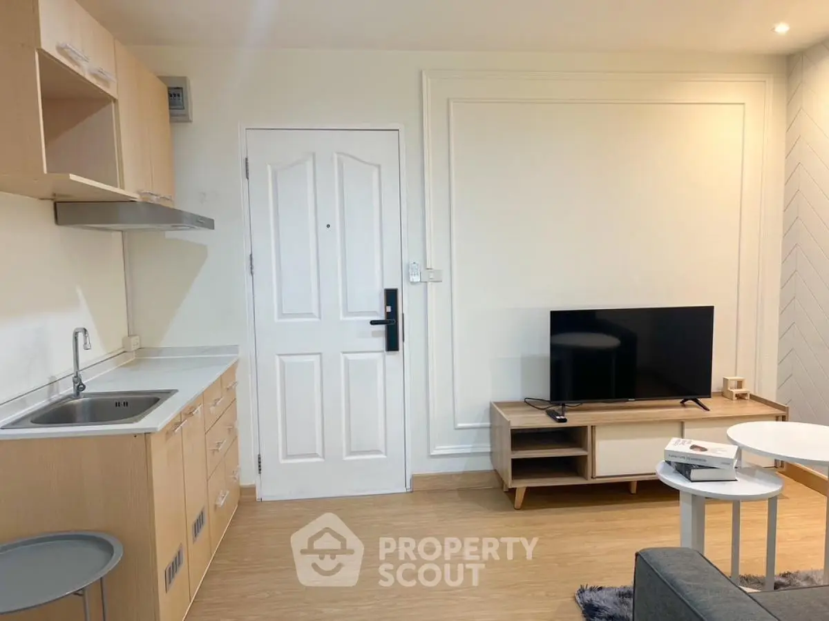 Modern living room with sleek TV stand and compact kitchen area