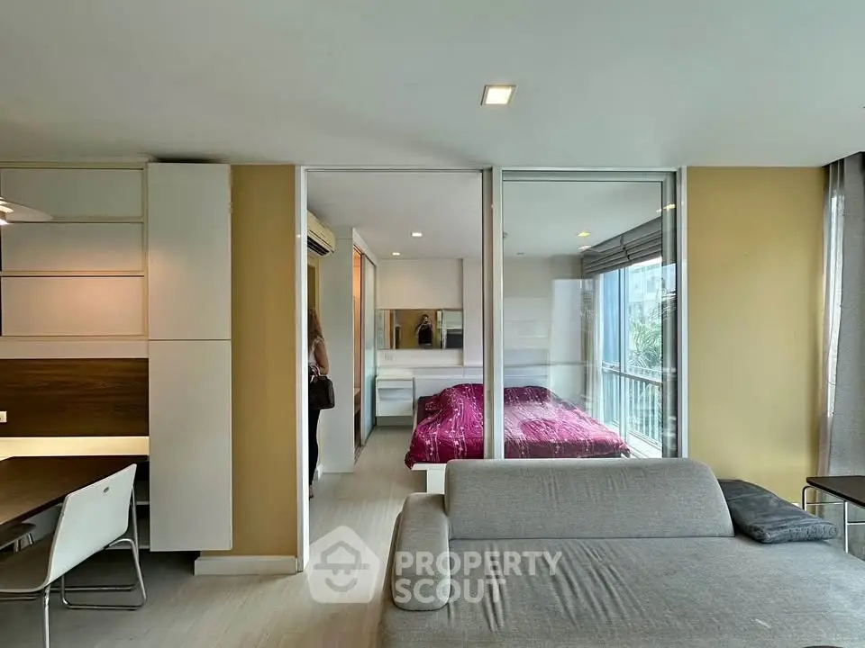 Modern open-plan living room with glass partitioned bedroom and stylish decor