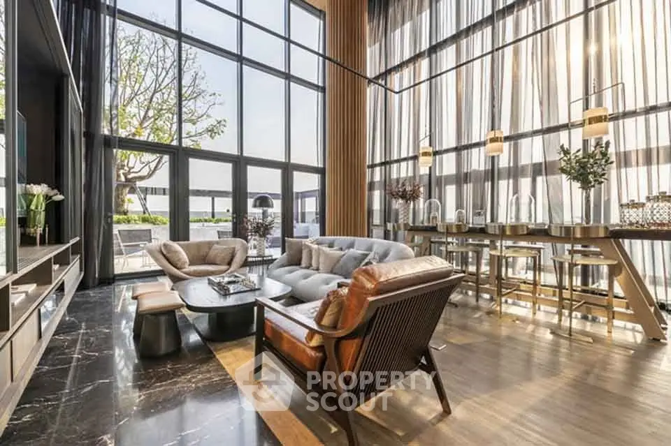 Luxurious modern living room with floor-to-ceiling windows and elegant furnishings, offering a stunning view.