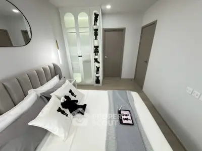 Modern bedroom with stylish decor and plush bedding in a contemporary apartment.