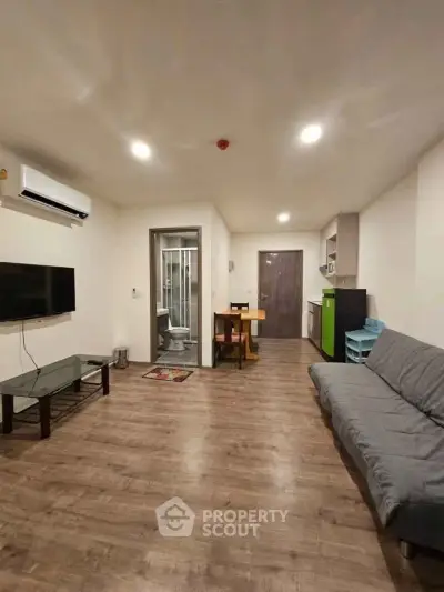 Modern living room with wooden flooring, sleek furniture, and open layout in a contemporary apartment.