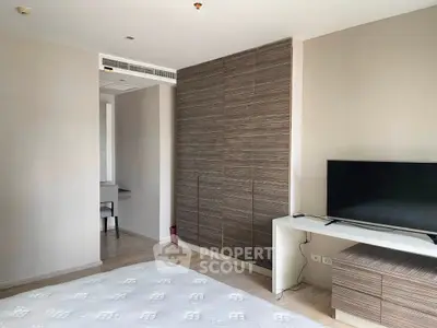 Modern bedroom with sleek TV setup and stylish wooden wardrobe, perfect for urban living.