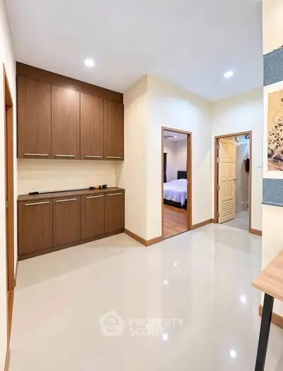 Spacious hallway with elegant cabinetry and access to bedrooms, showcasing modern interior design.