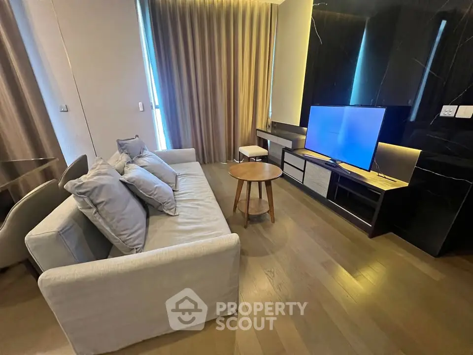Modern living room with sleek furniture and large TV, perfect for relaxation and entertainment.