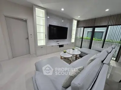 Luxurious modern living room with sleek design and large TV, perfect for relaxation.