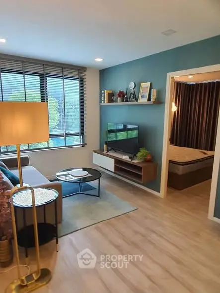 Modern living room with stylish decor and large window offering natural light.