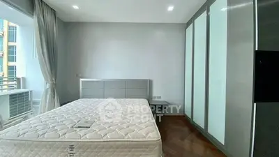 Spacious modern bedroom with large windows and sleek wardrobe