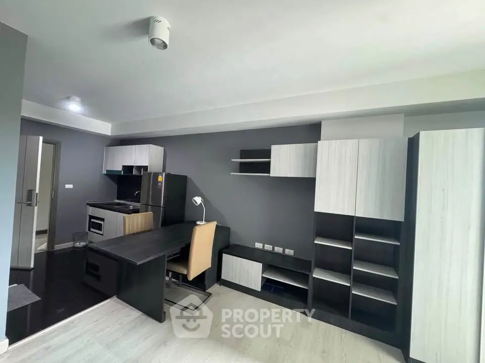 Modern apartment interior with sleek furniture and built-in storage solutions.