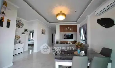 Elegant open-plan living and dining area with modern decor and chandelier