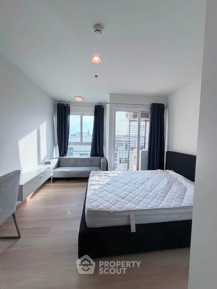 Spacious bedroom with large windows and city view, featuring a comfortable bed and modern decor.