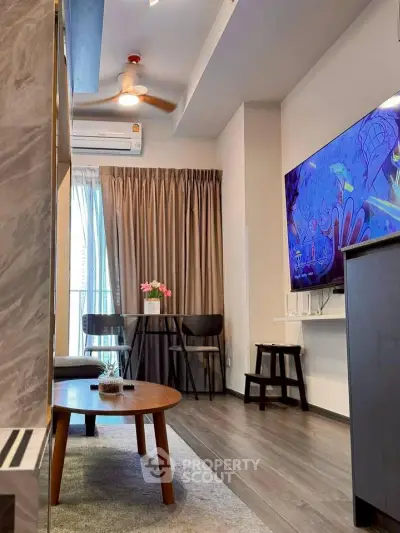 Modern living room with stylish decor, flat-screen TV, and cozy seating area.