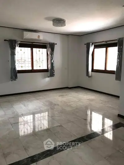 Spacious empty living room with large windows and marble flooring