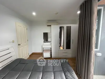 Modern bedroom with sleek furniture and cozy ambiance, featuring a stylish wardrobe and elegant curtains.