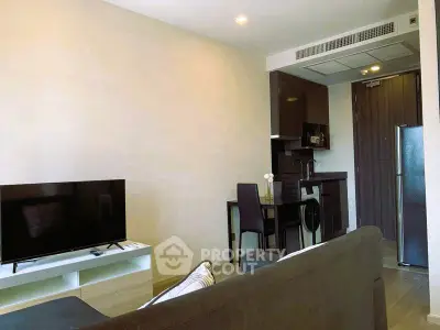Modern living room with open kitchen and sleek furniture in a stylish apartment.