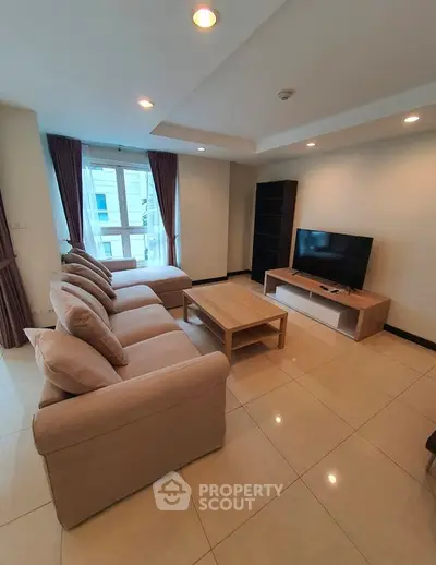 Spacious living room with modern furniture and natural light in a stylish apartment.