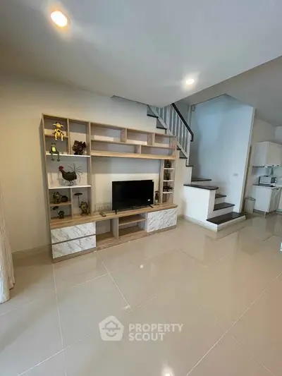 Modern living room with stylish TV unit and staircase, perfect for contemporary homes.