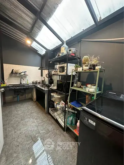 Modern kitchen with open layout and skylight, featuring sleek appliances and ample storage space.