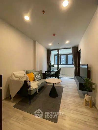 Modern living room with stylish decor and large windows in a cozy apartment.